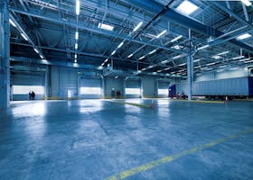 Large warehouse interior with docked truck, ideal for logistics and warehousing.